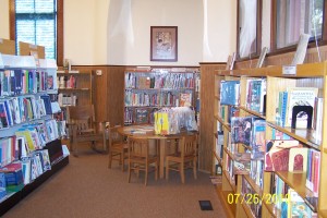 small wood table and chairs surrounded by shelves of children's books